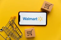 a smartphone with the walmart logo and shopping carts on a yellow background